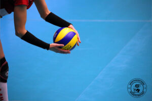 A person prepares to serve a volleyball