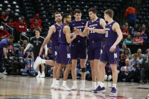 Northwestern basketball players huddle together.