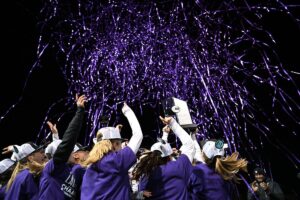 The lacrosse team celebrates with purple confetti after their Big Ten win