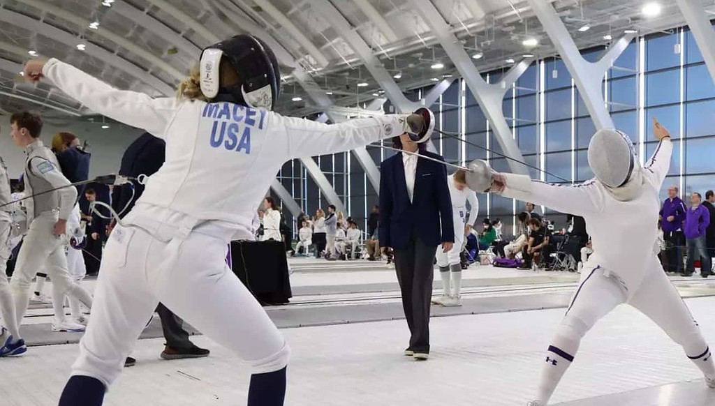 Two fencers engage in competition