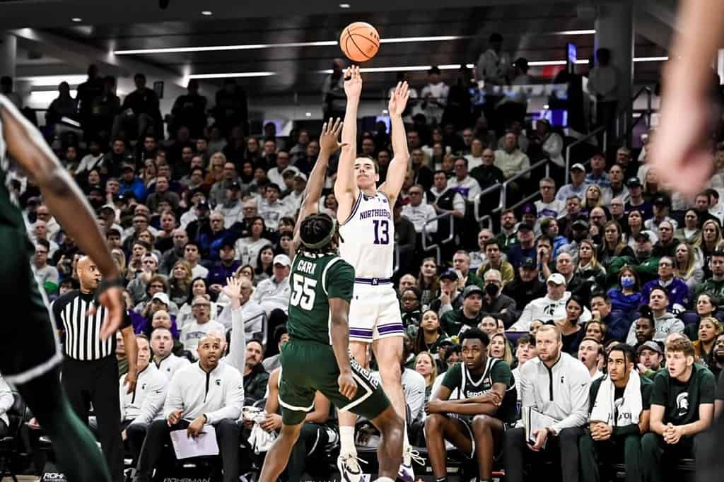 Brooks Barnhizer of Northwestern shoots over Michigan State's Coen Carr