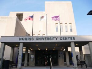 Picture of the front of Norris University Center, including the US, Illinois and NU flags. Taken during the daytime in sunlight.